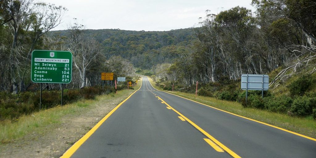 A rural highway curving through wooded green hills