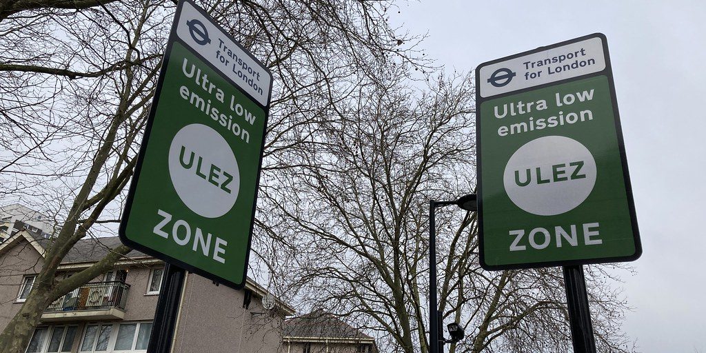 Two green Ultra Low Emission Zone signs at the edge of the zone