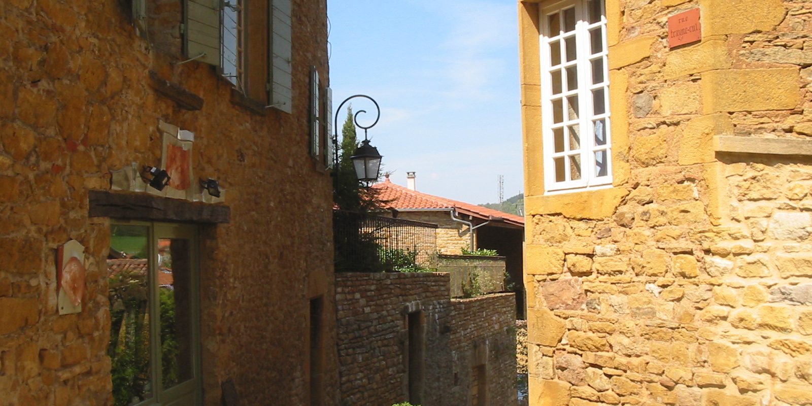 A stone house with shutters on a village street in France