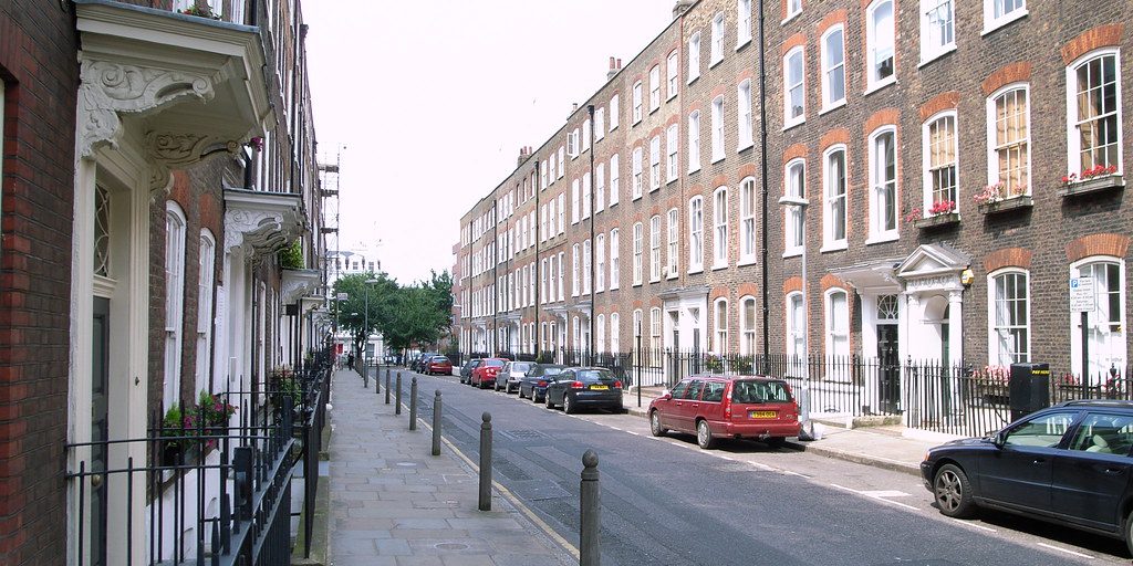 A street of Georgian terraced houses with cars parked along it