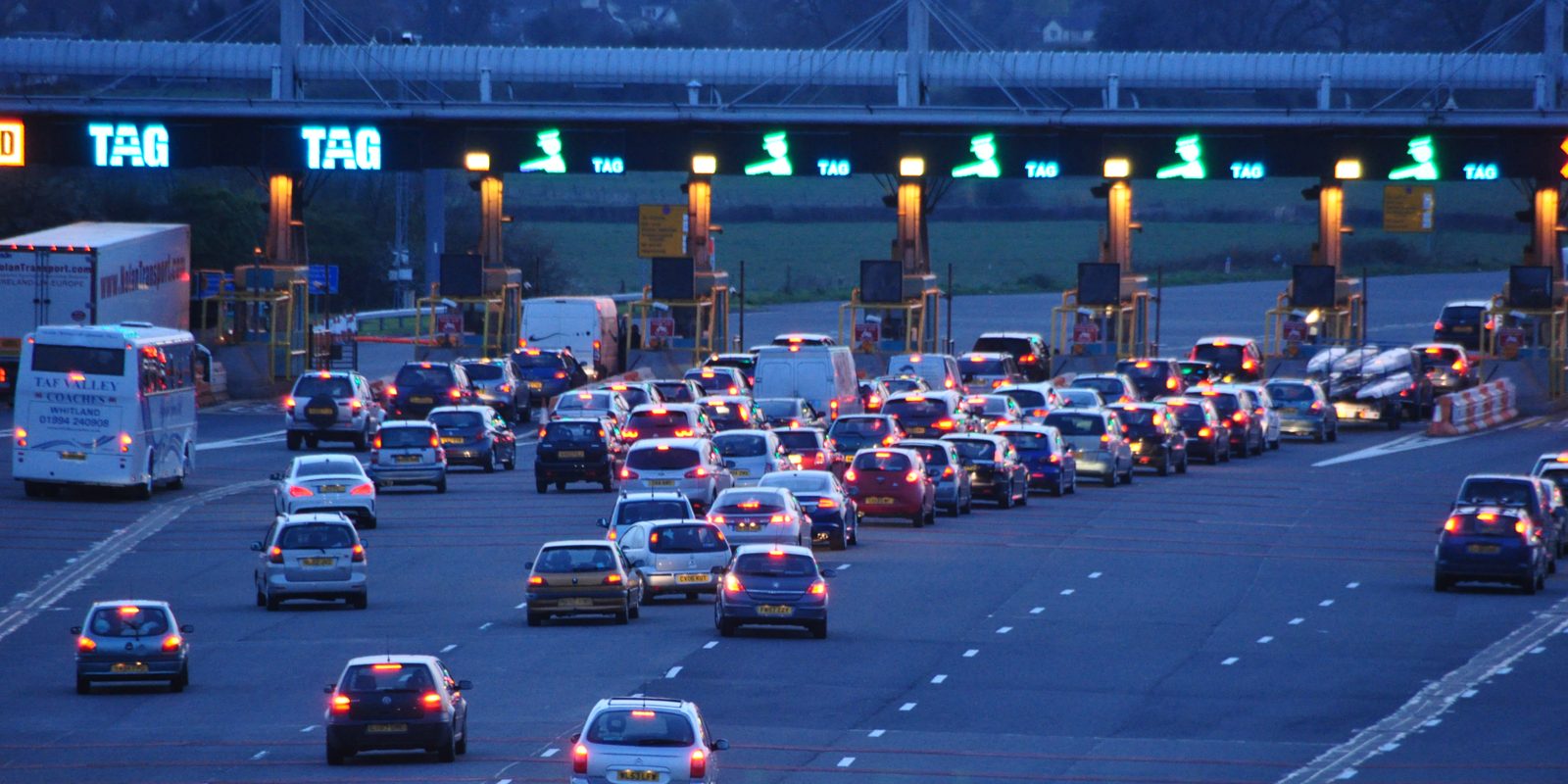 Cars passing through the lanes of a motorway toll plaza
