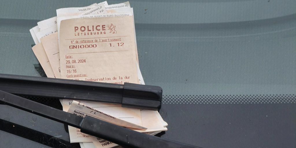 A penalty notice tucked under a car windscreen wiper
