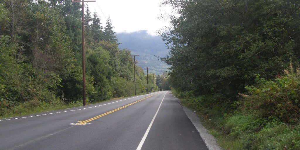 An empty road running through forested hills