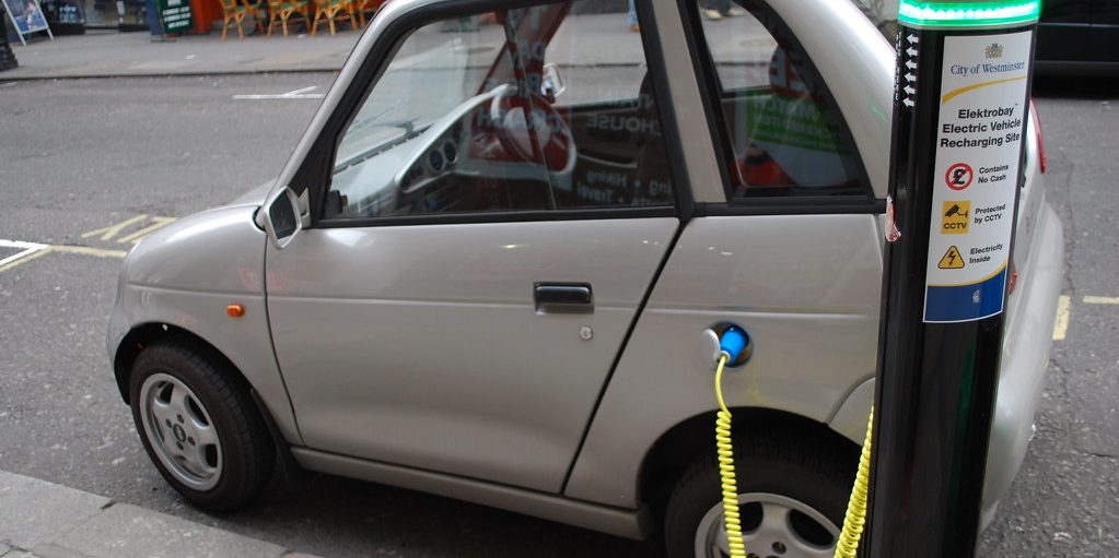 An electric car plugged into a street charging point