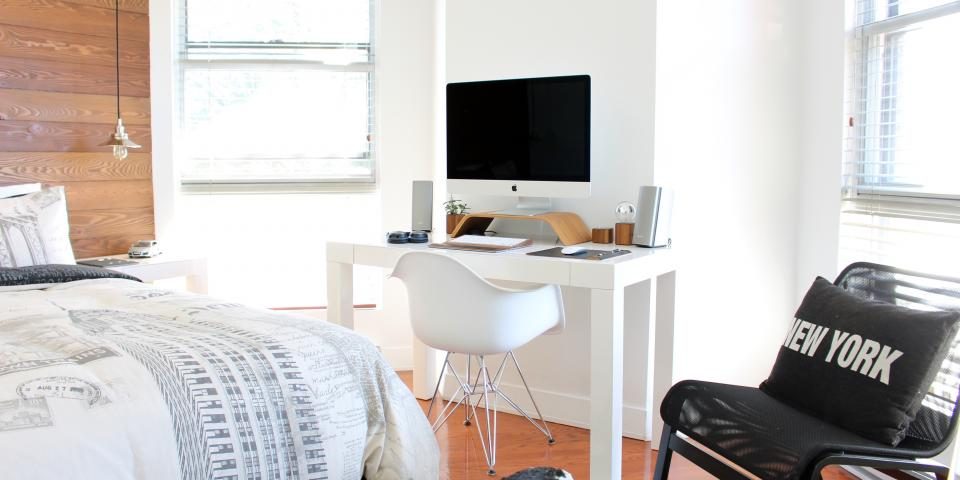 A home office desk with a computer by a window